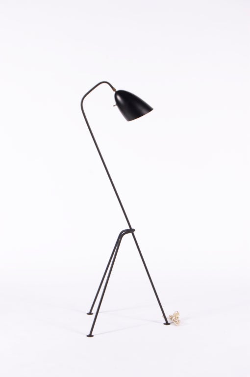 Tripod standing task lamp on cantilevered
iron base with streamlined conical head.