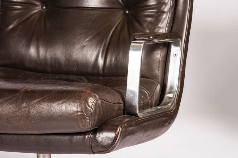 Pair of brown leather armchairs with canted chrome arms on post and wishbone leg feet. Priced per pair.