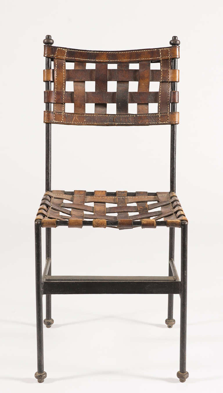 Hand-wrought iron side chair with woven leather seat and back.