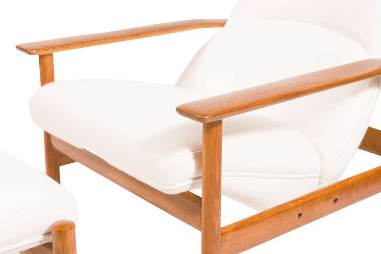Reclining armchair with matching ottoman, padded seat and back, polished teak upholstered in cream boiled wool.