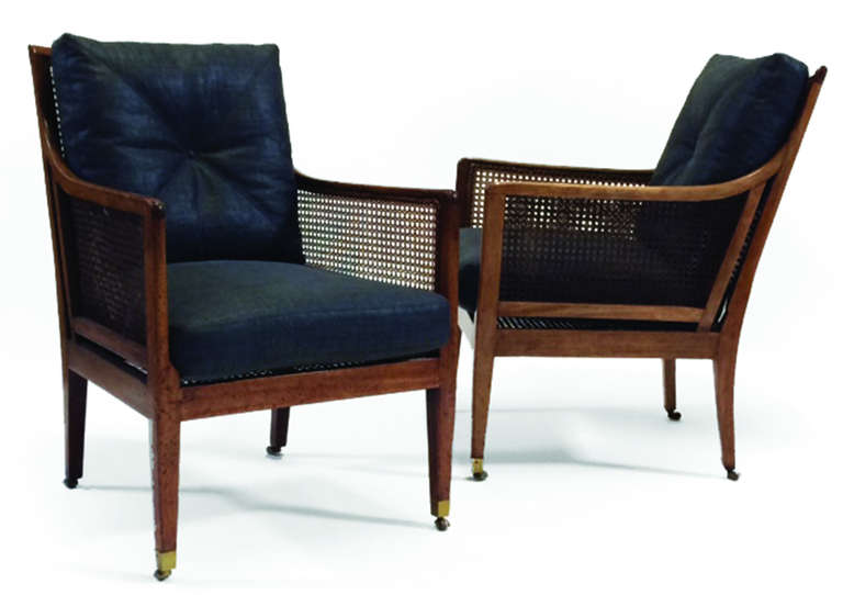 Regency Mahogany and Cane armchairs. With flared rectangular caned back, down swept arms above cane paneled sides on square tapered legs ending on casters, upholstered in
gray lacquered linen.