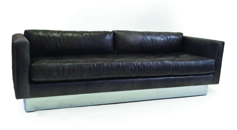 Rectilinear sofa on polished chrome inset base, single boxed seat cushion with baseball stitch detail, two single boxed cushion back pillows upholstered in seal color leather.