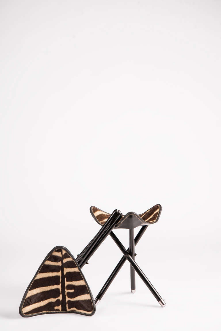 Pair of campaign stools with collapsible black lacquered wooden base with chrome caps. Triangular Zebra seats. Priced per pair.

All Sales Final - No Additional Discount