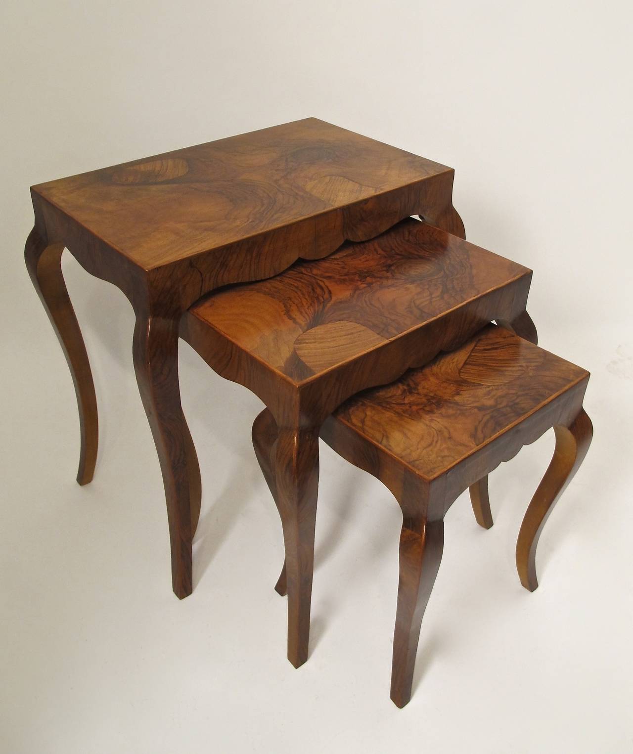 A set of three nested burled walnut tables.