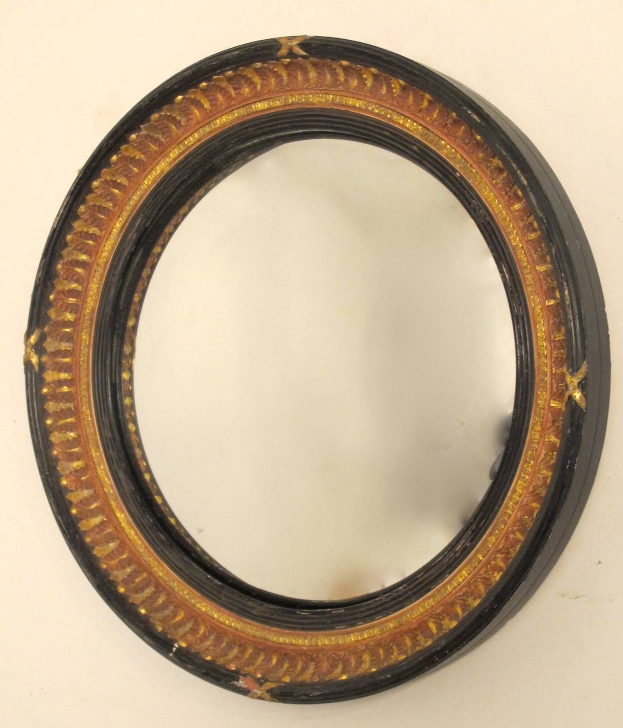 Regency style black and parcel-gilt convex mirror. Black painted outer edge and reeded rim and inner ring, painted palmett leaves and parcel-gilt band and cross ribbons. English, early 20th century.