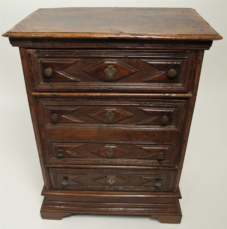 Small walnut comodino with four drawers. Italy, late 17th/early 18th century.