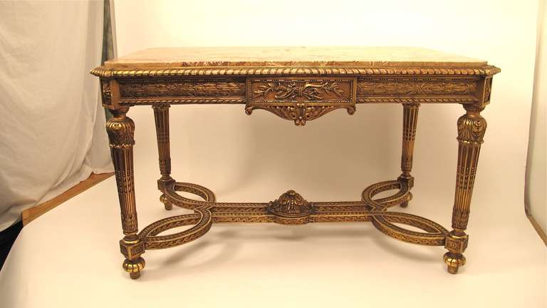 Carved, gessoed, and gilt wood center or console table with original inset marble top.