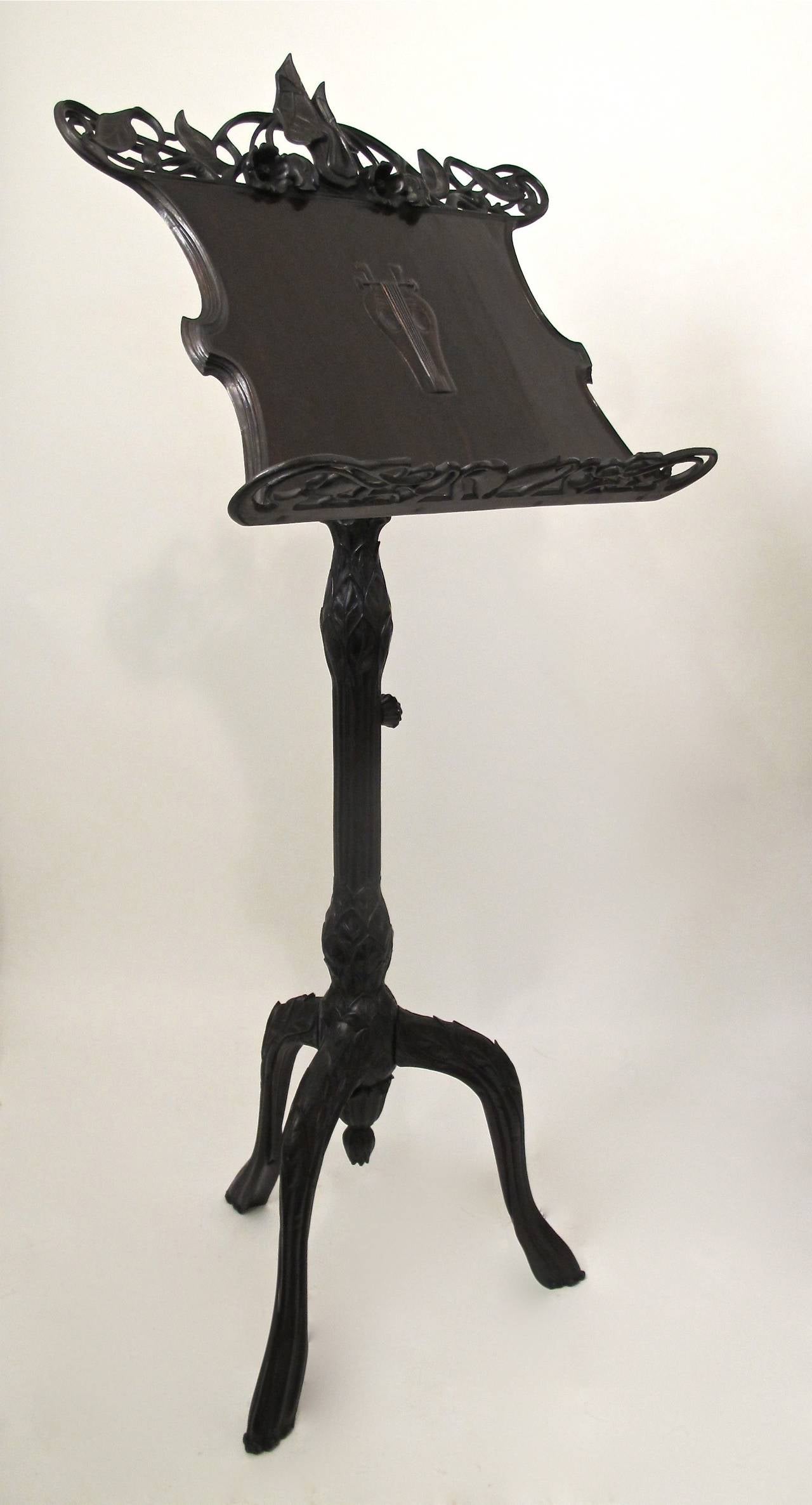 Outstanding hand-carved music stand with wonderful detailing of scrolling vines with leaves and flowers through out the entire piece. Beautifully carved flower head knobs on the sheet music tilting rest and height adjuster, fully carved center pole