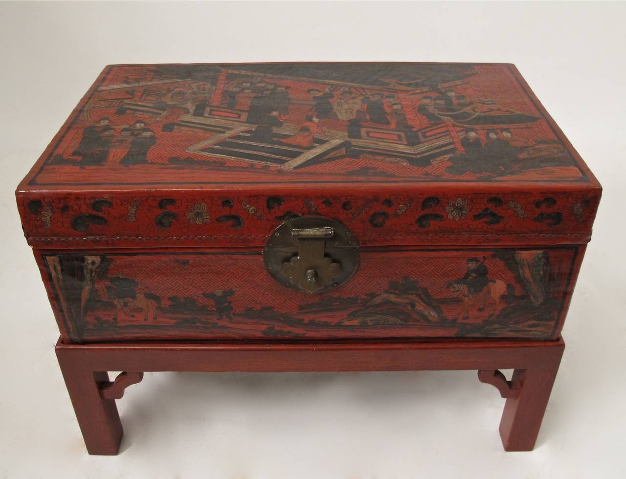 Unusual pigskin trunk with embossing and hand painted garden pavillion court scenes on red lacquered ground. Custom made later stand. Chinese Qing Dynasty (late 19th century).