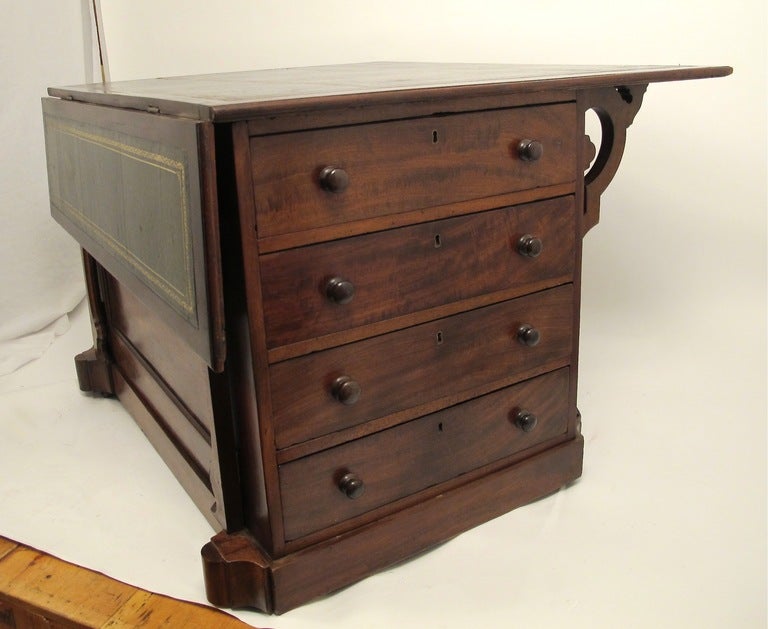 Mahogany cabinet with one drop leaf, drawers on both sides, and inset leather top. American or English, mid 19th century. Measurements below are for table top fully open.