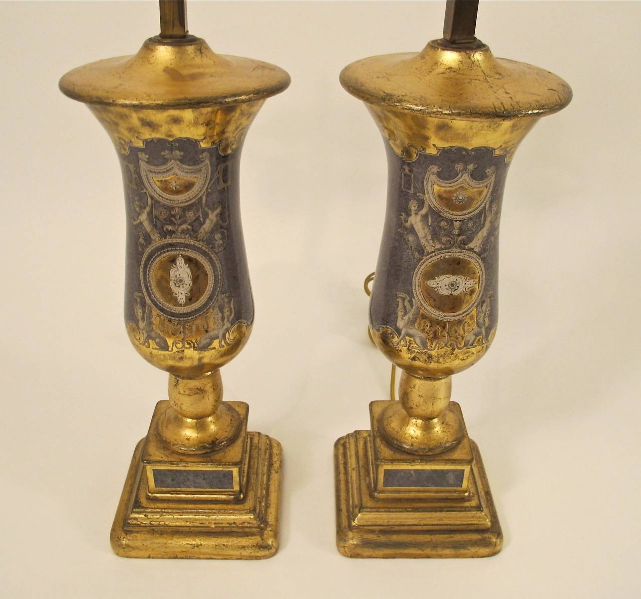 An outstanding pair of églomisé table lamps. Reverse painted on glass with giltwood bases. Recently re-wired, holds two standard size bulbs.