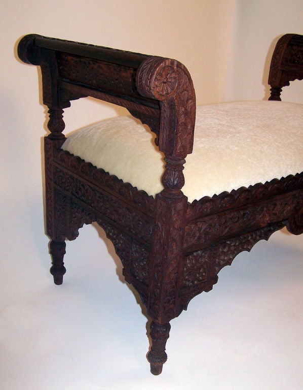 Elaborately carved bench with new upholstery in cream colored velvet mohair. Bench is very sturdy.