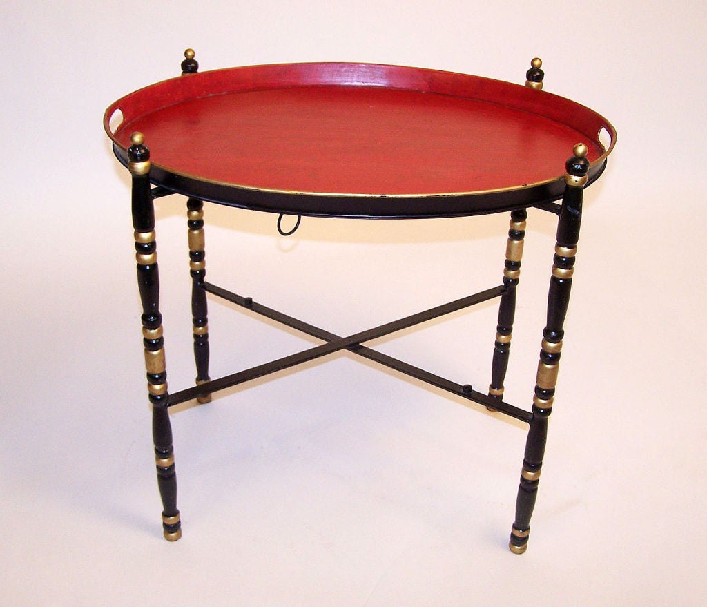 Tole painted tray in vibrant red color on black and gold painted folding metal stand. Italy, mid-20th century.