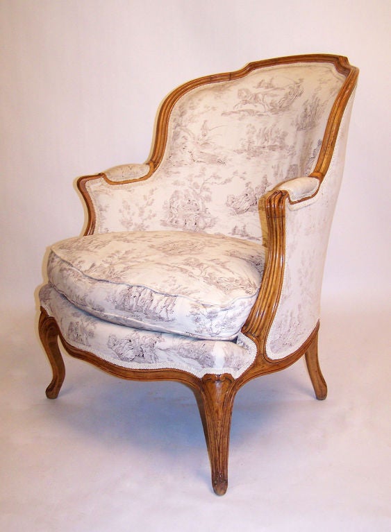 Pair of Louis XV Style Bergere with sculpted frame sitting on four cabriole legs.  Upholstered in cotton toile, will need to be reupholstered.  French, Circa 1880.

