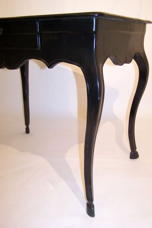 French black lacquered writing table with graceful legs an hoof feet. The table is made of fruitwood and was lacquered in the 1960's