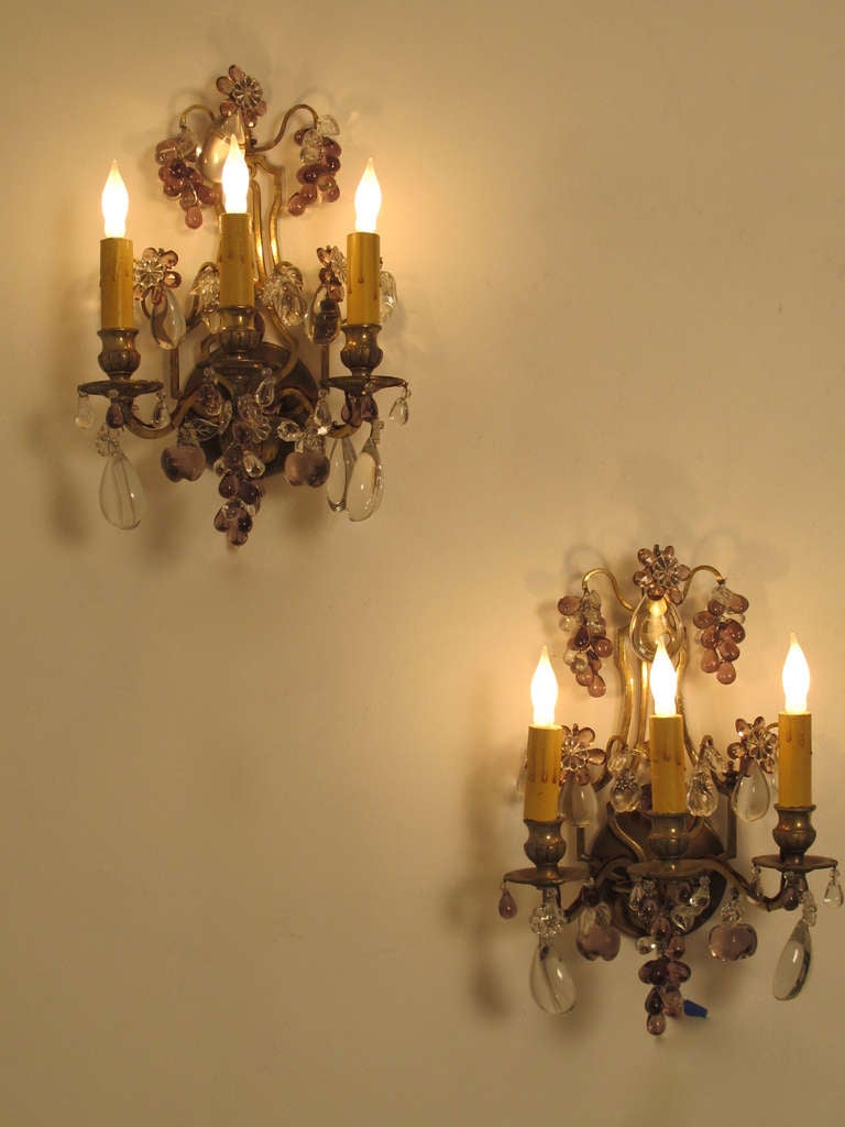 Pair of three light brass wall sconces with amethyst and clear glass fruit and flowers. The graceful back mounting is brass. French, Circa 1920.