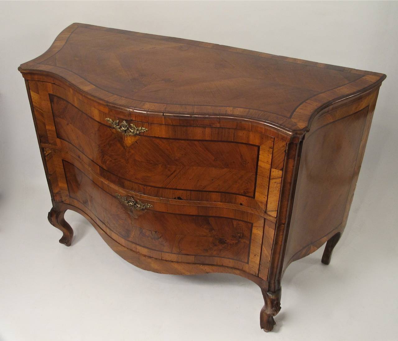 Exceptional two-drawer walnut commode or chest of drawers with walnut and walnut inlay on carved cabriole legs, Italy, mid-18th century.