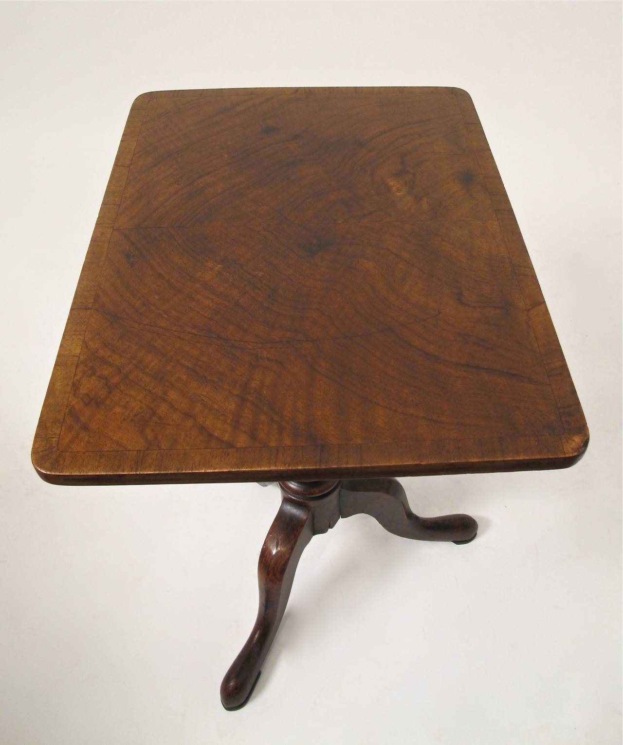 Walnut side table with walnut banding and carved barley twist column on three splayed legs with pad feet.