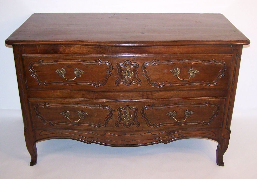 An 18th century French Provincial two drawer walnut commode with a slightly serpentine front. Beautiful antique condition, recently refinished. 