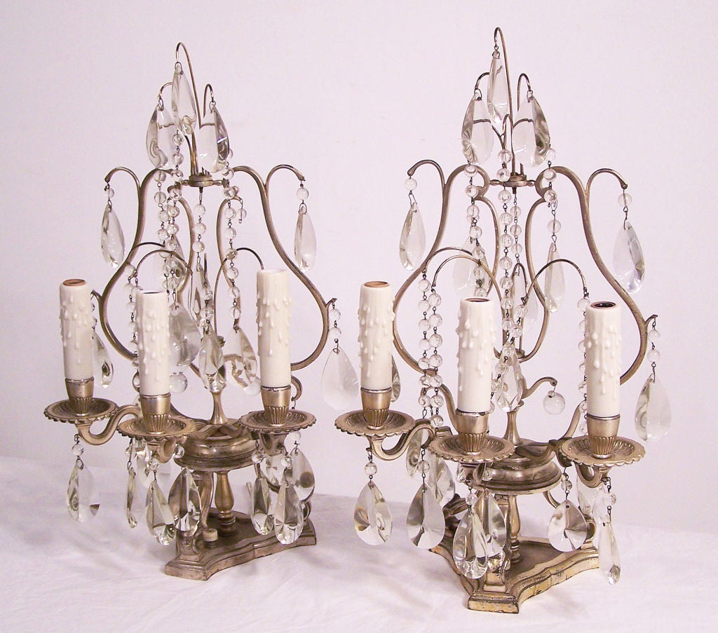 A lovely pair of silver plated table or mantle lamps with glass prisms and beads. Recently re-wired and ready to use,. Sockets hold a small chandelier type bulb. 
Circa 1930.