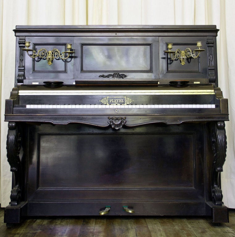 Pleyel upright piano with original brass candle holders and moving handles.<br />
History:Ignace Pleyel a fine pianist and student of Haydn was born<br />
1757 in Austria.As a musician in his early years he actively worked<br />
with Haydn on