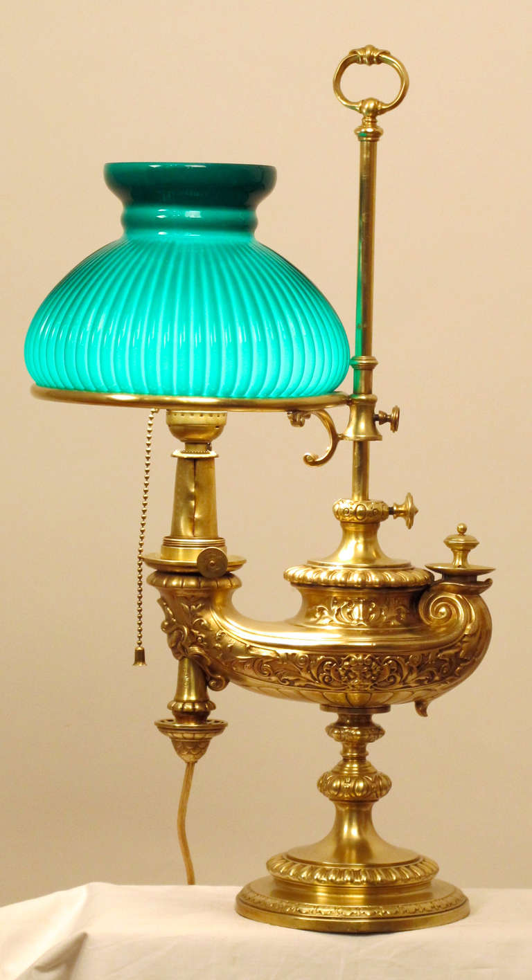 Aladdin Style German Brass Kerosene Student Lamp, converted to electric.
Manufacturer is Wild & Wessel, Berlin. Shade is green case glass with white interior. Has very minor dents and indication of user wear on brass.  German, 19th. Century.
