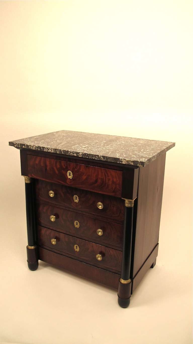 Unusual size four drawer mahogany commode with bronze mounted and ebonized columns, original brass hardware, and original gray and white veined marble top.  France, circa 1830's.