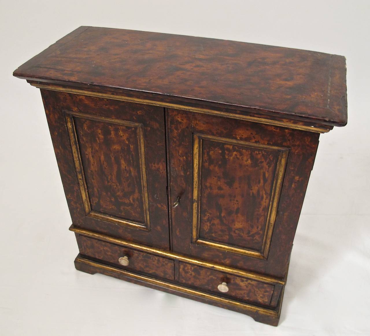 Small antique cabinet (possibly a craftsman's sample or apprentice model) with original paint done in a faux tortoise shell with gilt detailing. Key fits but does not throw lock. In remarkable condition. European, mid 19th century.