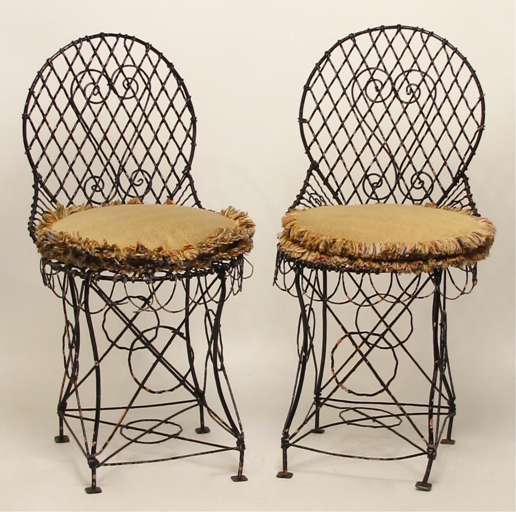 Pair of charming bent wire garden chairs with detachable cushions. Chairs have several layers of old paint. Cushions are in excellent condition.