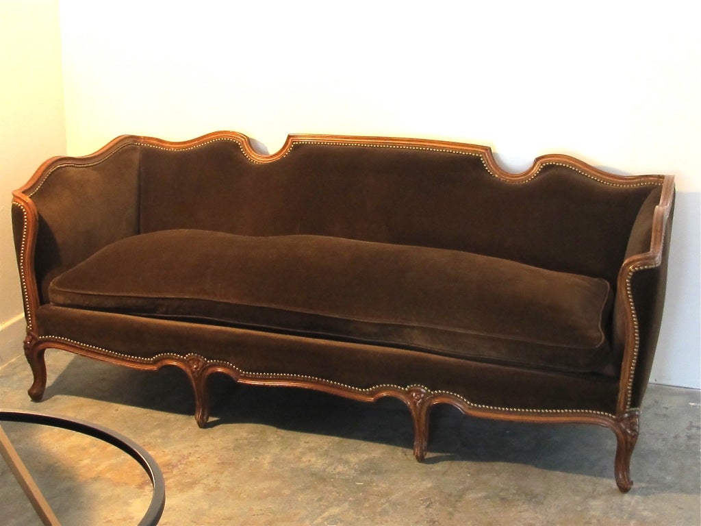 Large scale sofa with dark brown velvet upholstery and down cushion. Great looking shape and curves, with carved fruitwood frame.  Extremely comfortable sofa.