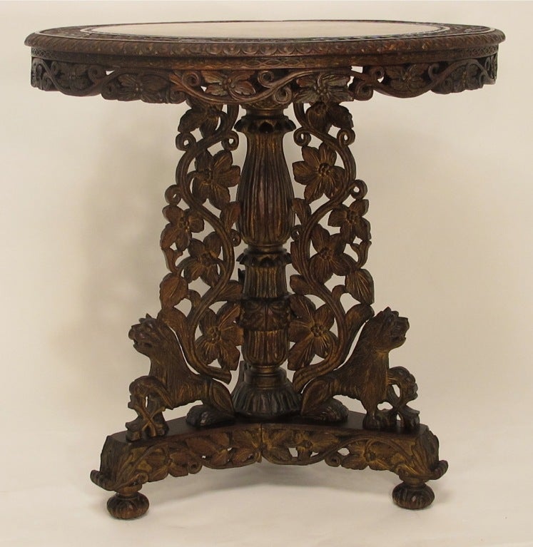 An elaborately carved and detailed rosewood center table or side table with remnants of original gilding in recessed areas.
India, late 19th century.
In remarkable original antique condition.
