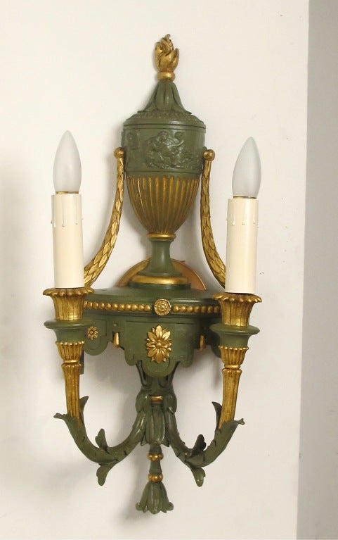 Pair of Neoclassical style two-arm sconces with painted wood and molded composition bodies that have gilt metal details. Newly rewired and in working condition. We have 4 available, sold in pairs at $1850.00 each pair.