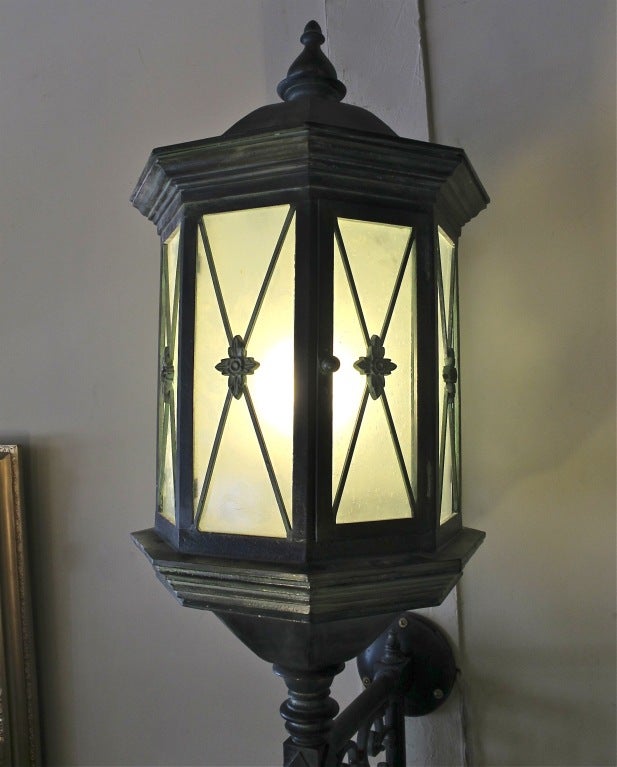 An extraordinary pair of very large and impressive Baroque style cast iron wall-mounted lanterns. Completely and professionally refurbished with a beautiful verdi gris finish, rewired for exterior and interior use, American, early 20th century.
