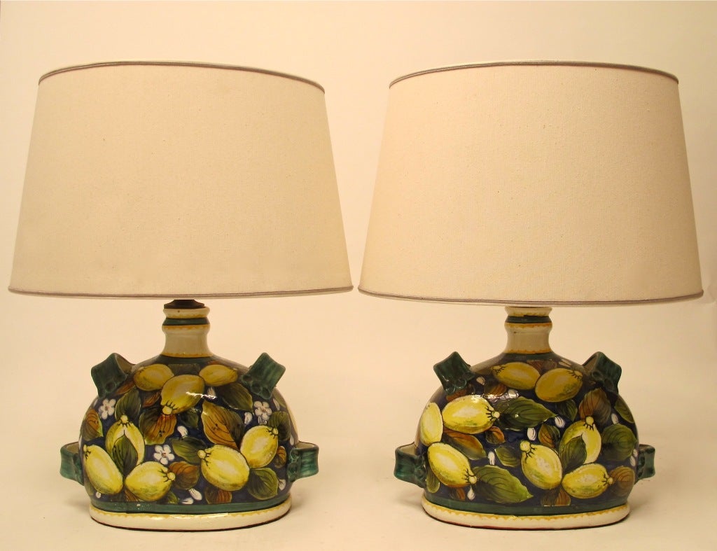 A large pair of beautifully painted and glazed Italian faience lamps. Lemons and leaves on a blue background, having original custom-made elliptical shaped shades. Newly re-wired, Italy, mid-20th century.