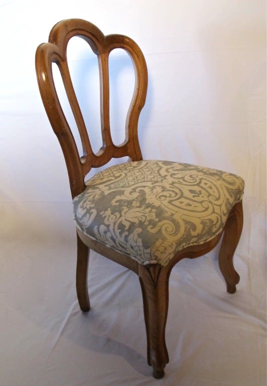 Set of eight European (possibly Austrian) fruitwood dining chairs with vintage Fortuny upholstery. These are substantial solid chairs, sturdy and sound. Most likely upholstered in the 1950s or 1960s, fabric shows light staining and spots.