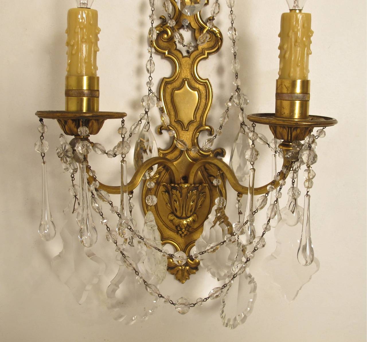 A pair of brass wall sconces with glass beaded swags and crystal pendants. Newly restored and re-wired. French, early 20th century.