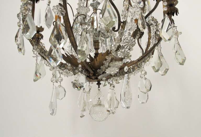 An exceptional pear shape eight light chandelier. The gilt metal frame accented with bold and robust large size crystal drops and glass buttoning along with gilt tole leaf highlights.  Italian, early 19th. century.