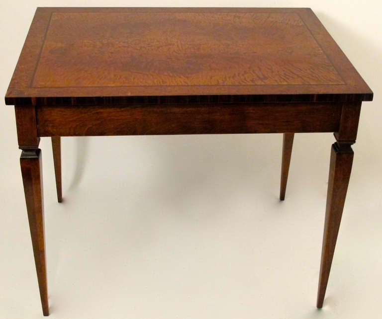 Finely crafted hand made table with Plum Pudding Mahogany center framed with inlay of ebony bordered by 2 inch band of burl walnut and edge banding of Rosewood, sitting on an apron and tapering legs of Black Walnut.  American, last half of the 20th