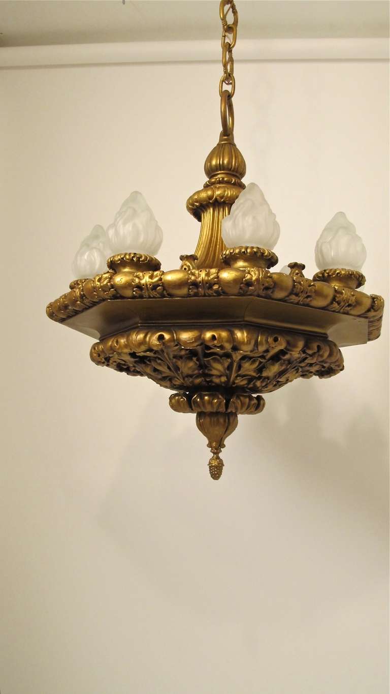 An impressive gesso and carved wood ceiling fixture. Exceptional quality and craftsmanship. Reconditioned and re-wired, newer flame shaped frosted glass shades. Shows some minor paint loss. Chain length is 20