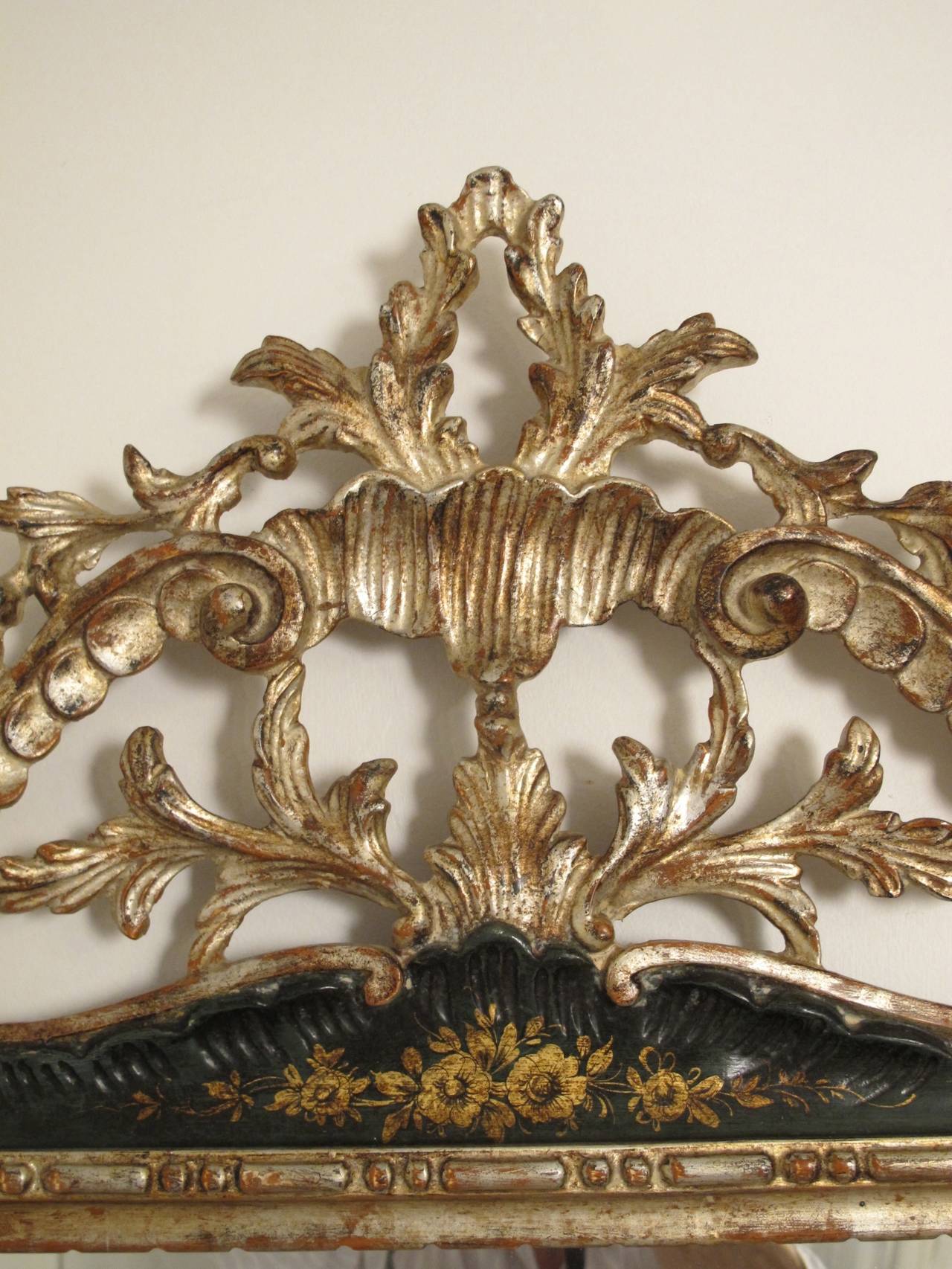 Highly carved silver gilt and parcel painted wood framed mirror. Dark forest green frame with carved acanthus and shell design. Mirror has a 1 inch bevel. Italian, 1940's-1950's.