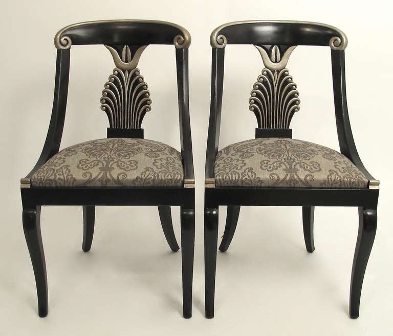 Black painted with silver detail with wool upholstered drop in cushion seats. Standing on sabre legs. Art Deco/Regency Hollywood style, American, first half of the 20th century.
