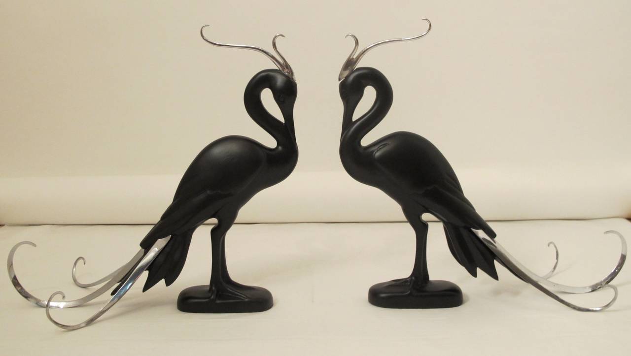 Pair of Moderne stylized exotic birds, carved and ebonized wood with flamboyant chrome plumes and tails. Circa 1950's-1960's.