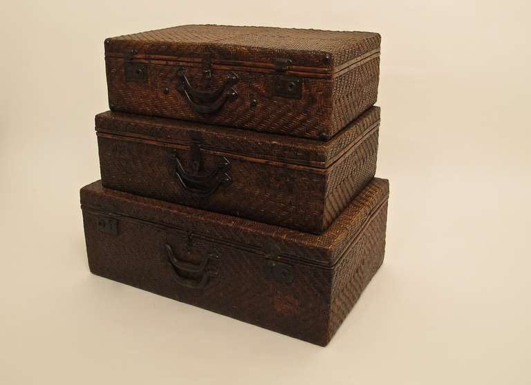 Set of 3 late 19th century woven suitcases with bamboo trim detail, all in original condition. Beautifully aged patina, and great color. The small case measures 7 1/4 High x 23 1/2 Wide x 14 3/4 Deep, medium case 7 3/4 High x 24 1/4 Wide x 16 3/4