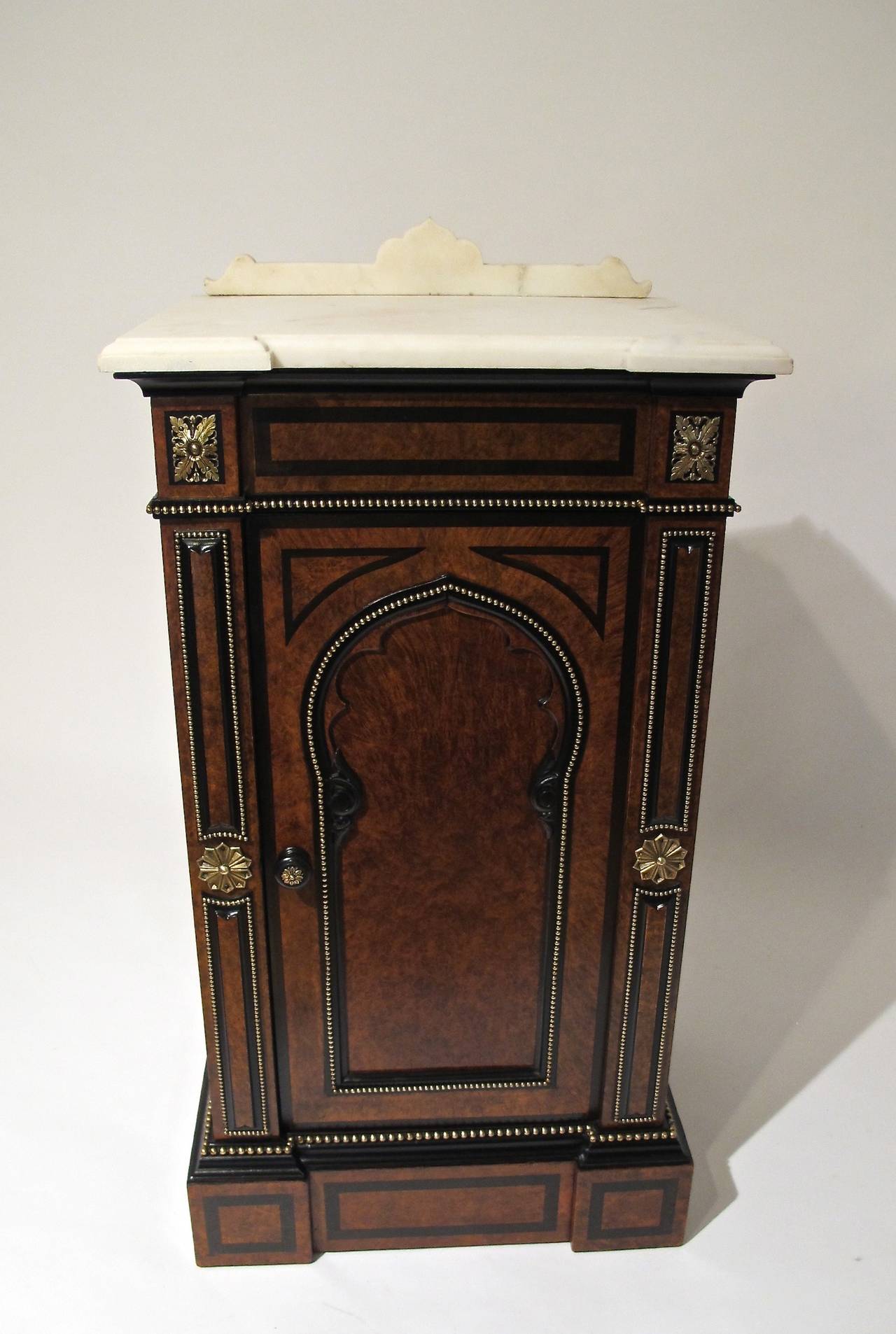 Moroccan or Arabesque style side cabinet/table. Beautiful mixed woods of burled walnut veneers and ebony with beaded brass trim,brass detailing and white marble top.