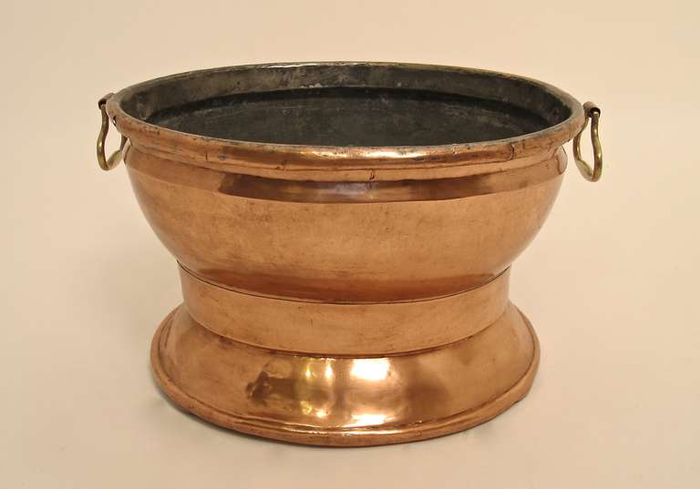 A large size footed copper pot with brass handles. Great looking pot with lots of character and signs of use.