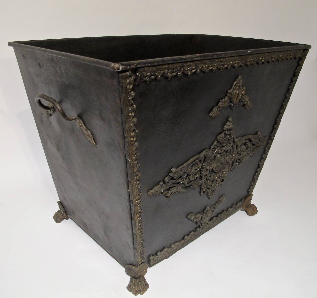 A very large storage bin, painted steel with brass mounts and decoration.