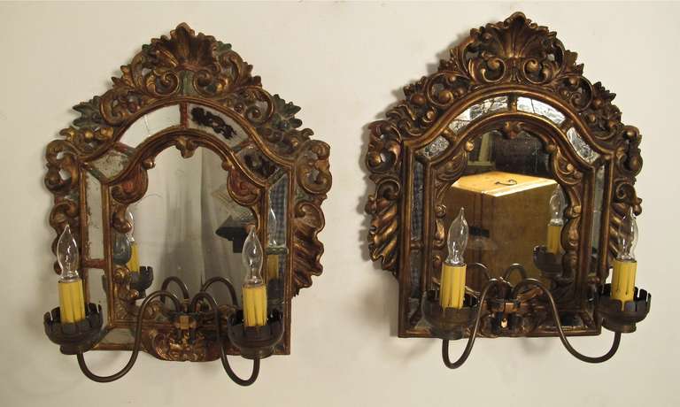 A pair of Baroque style, carved and gesso wood sconces with mirror backs. Late 19th/early 20th century.