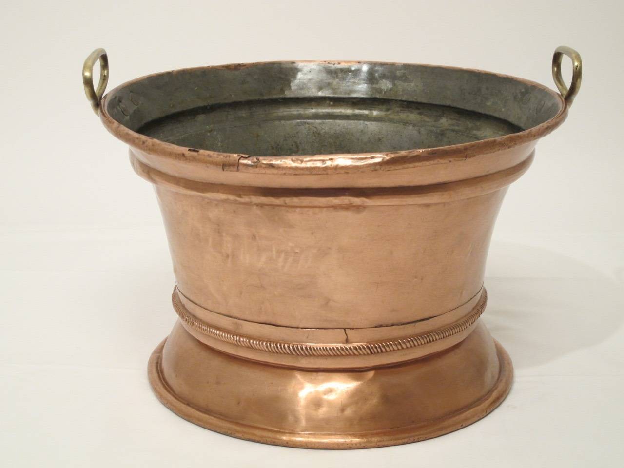 A large round copper pot with brass handles. Italian, circa mid-19th century.
