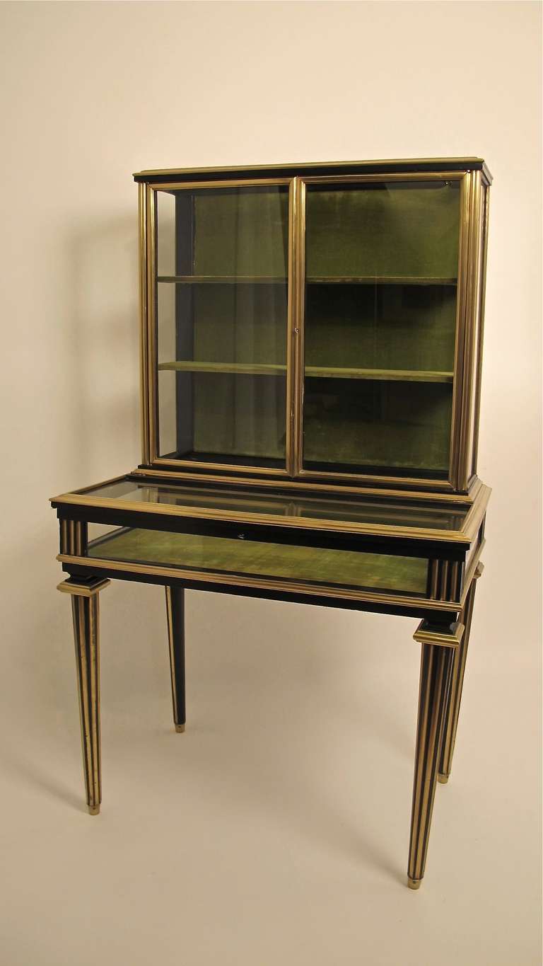 An especially attractive Napoleon III period display cabinet. Ebonized wood with brass trim and the fluted legs with brass fillet detail.