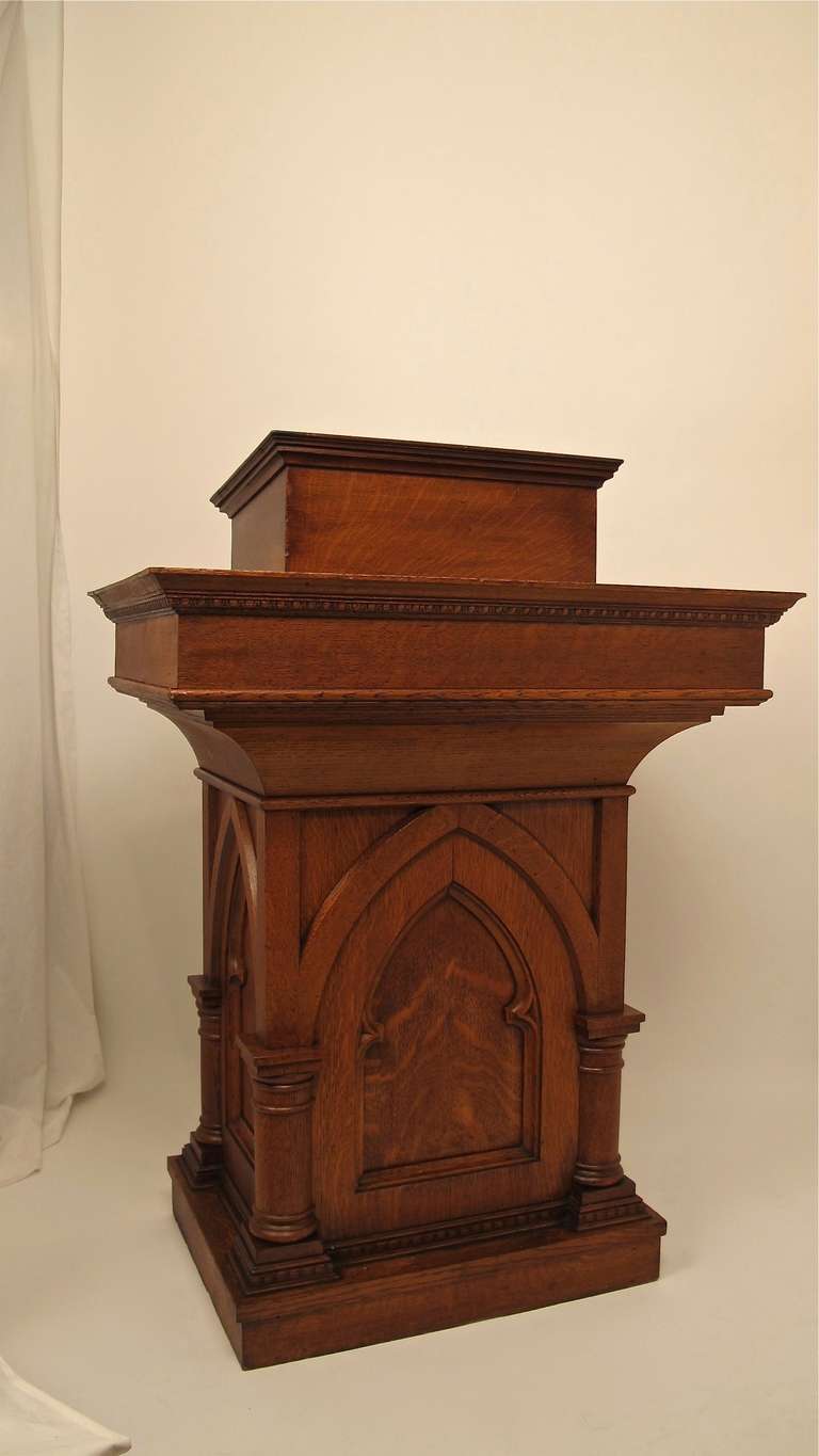 A late 19th century gothic style carved oak podium with original inset oil cloth book rest and felt lined cabinet below. Possibly from a church or fraternal organization. In excellent original condition.